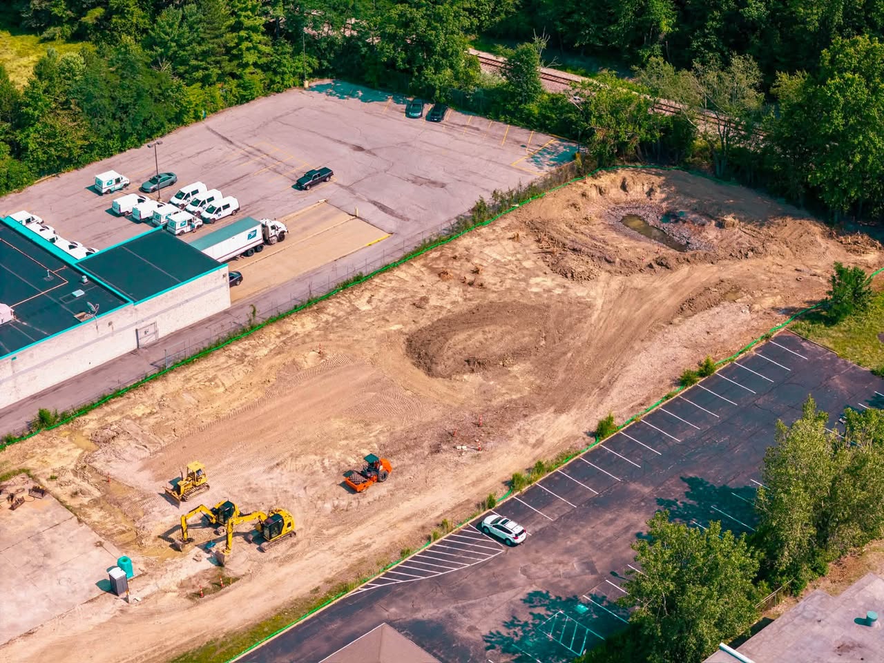Aerial drone view of the Apex Strength Club site showing the retention pond being built and heavy equipment grading the lot